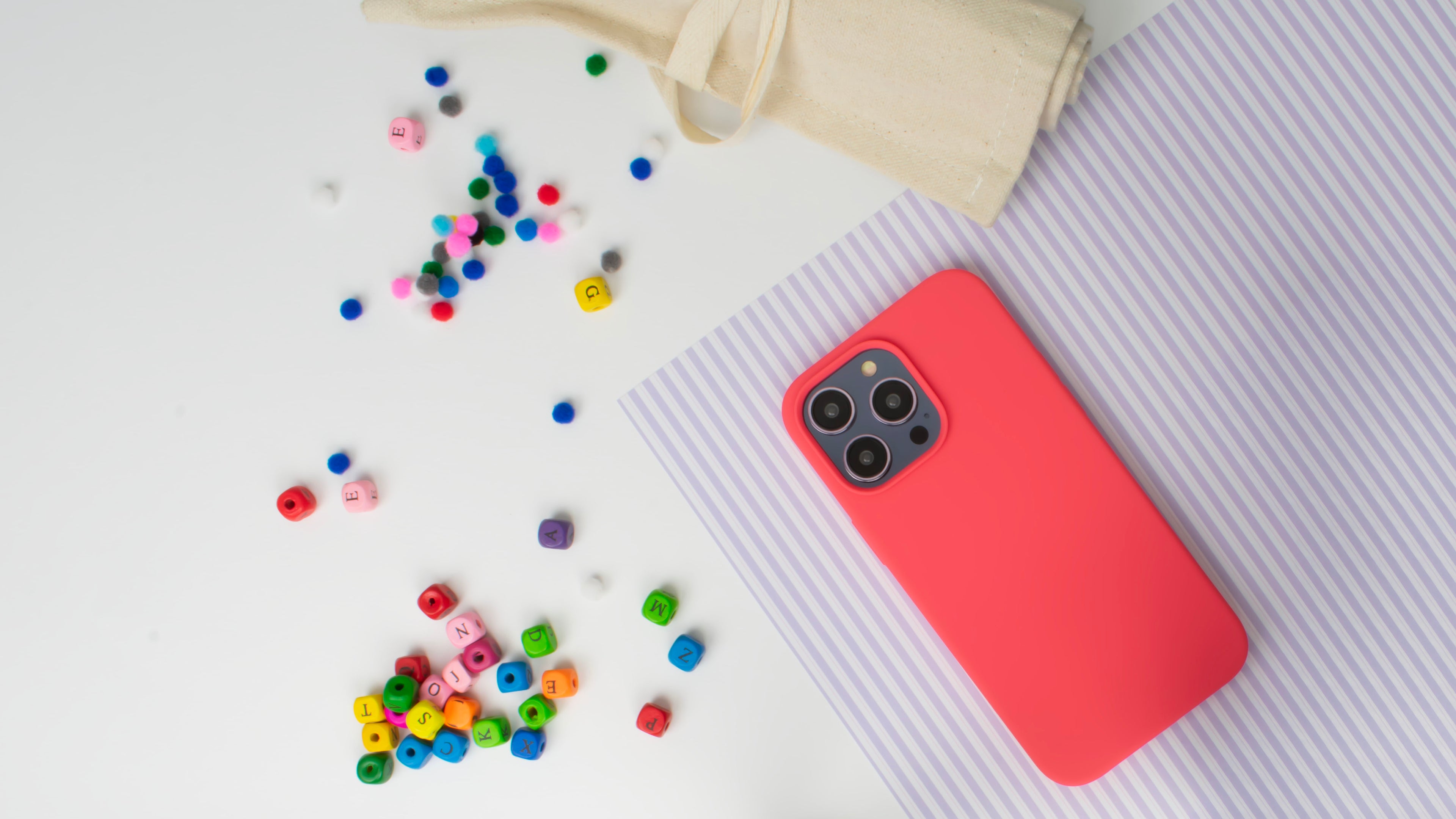 Lifestyle image of the SKNS SILICONE Soft Touch Blood Orange iPhone 14 Case on White table top